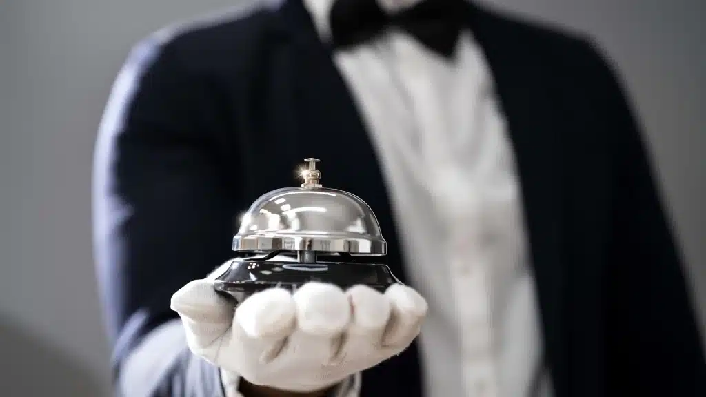 Condo concierge services staff holding a concierge bell representing hospitality and resident assistance in luxury condominium